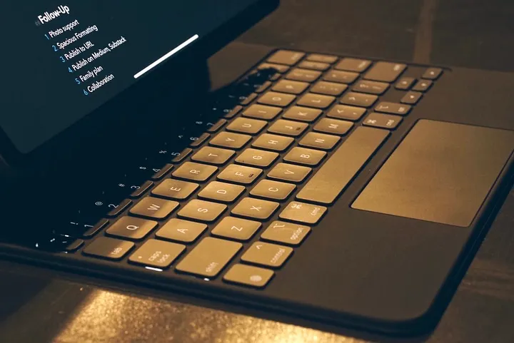 Close-up of a keyboard connected to a tablet displaying a "Follow-Up" list.